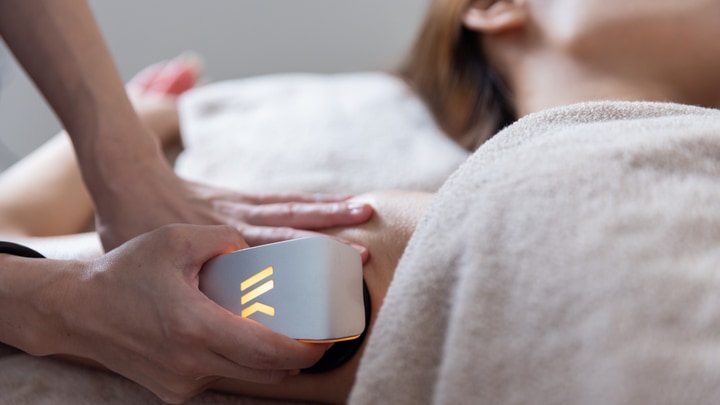 お腹にウィンバックのプローブを当てて温める施術の様子